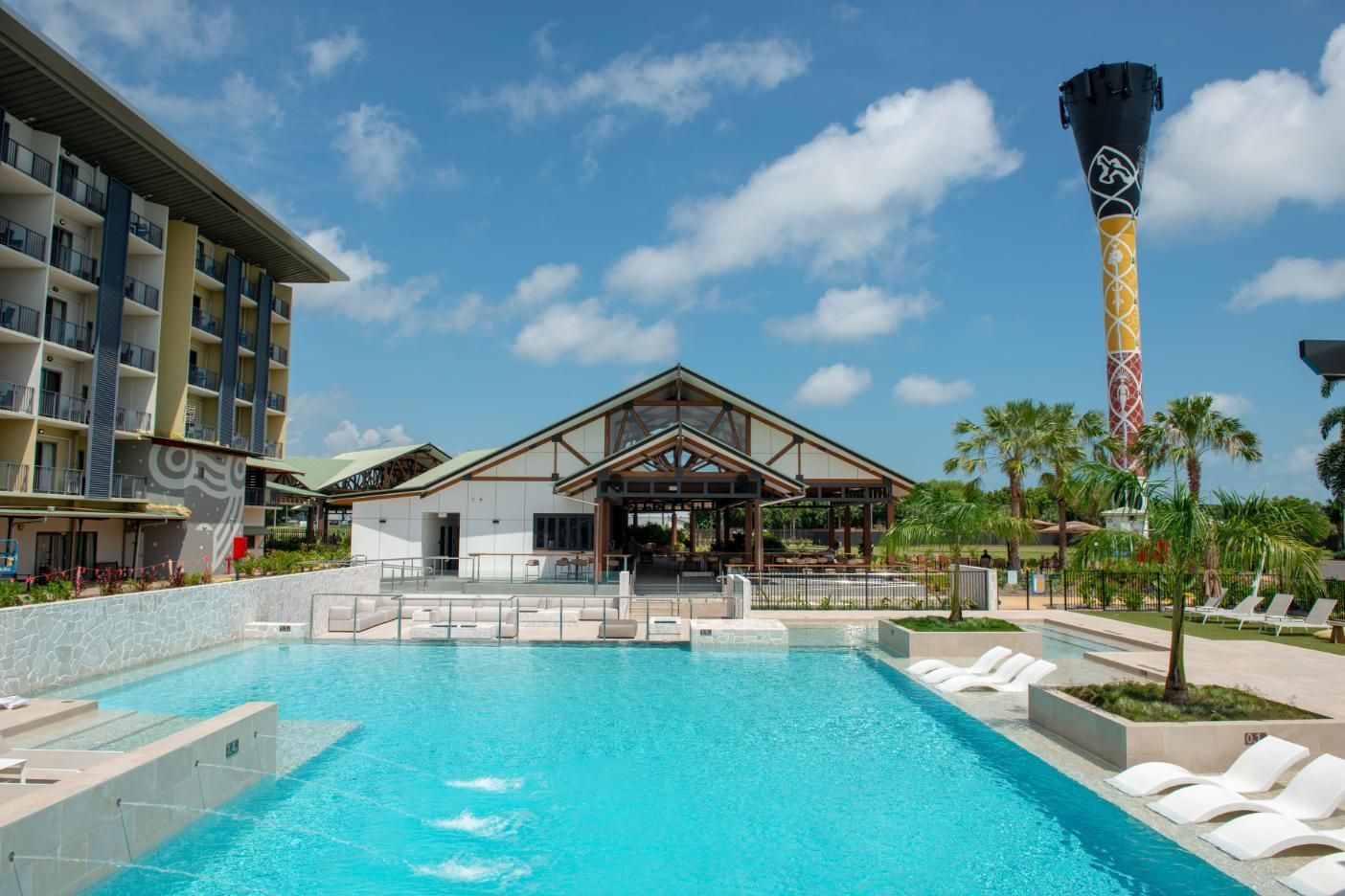 Two People Are Walking Down a Sidewalk Next to A Pool — Figleaf Pool Products in Coconut Grove, NT