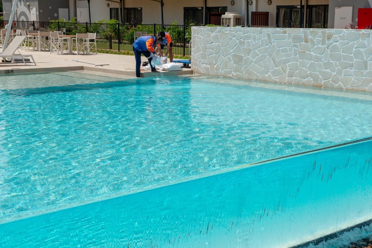 A Large Swimming Pool Surrounded by Chairs and A Building — Figleaf Pool Products in Coconut Grove, NT