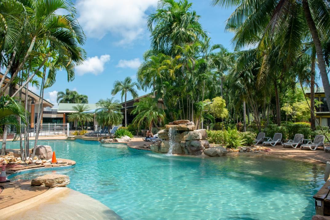 A Large Swimming Pool Surrounded by Palm Trees at A Resort  — Figleaf Pool Products in Coconut Grove, NT