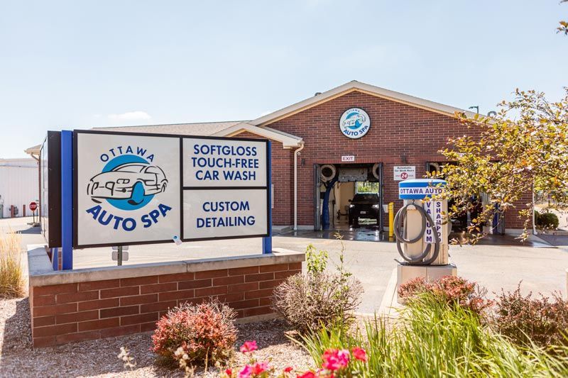 a car wash with a sign in front of it .