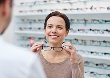 Woman showing glasses to optician at optics store — general in Yorktown, VA