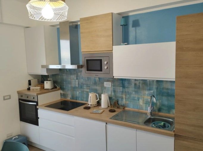 Una cucina con piano cottura lavello e forno a microonde