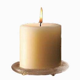 A lit, ivory-colored pillar candle on a textured, glass-like saucer, isolated on white.