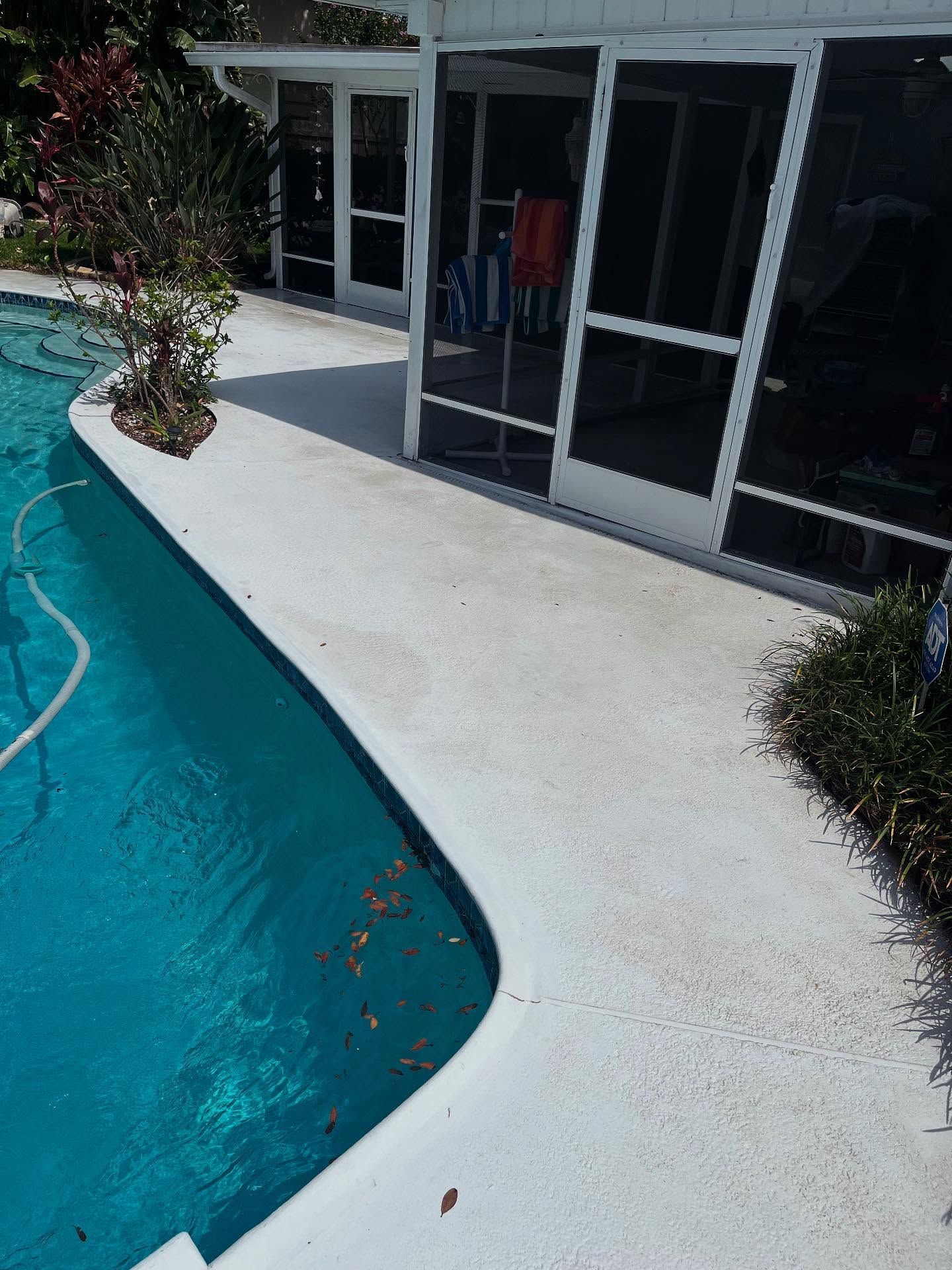 A screened in porch next to a swimming pool