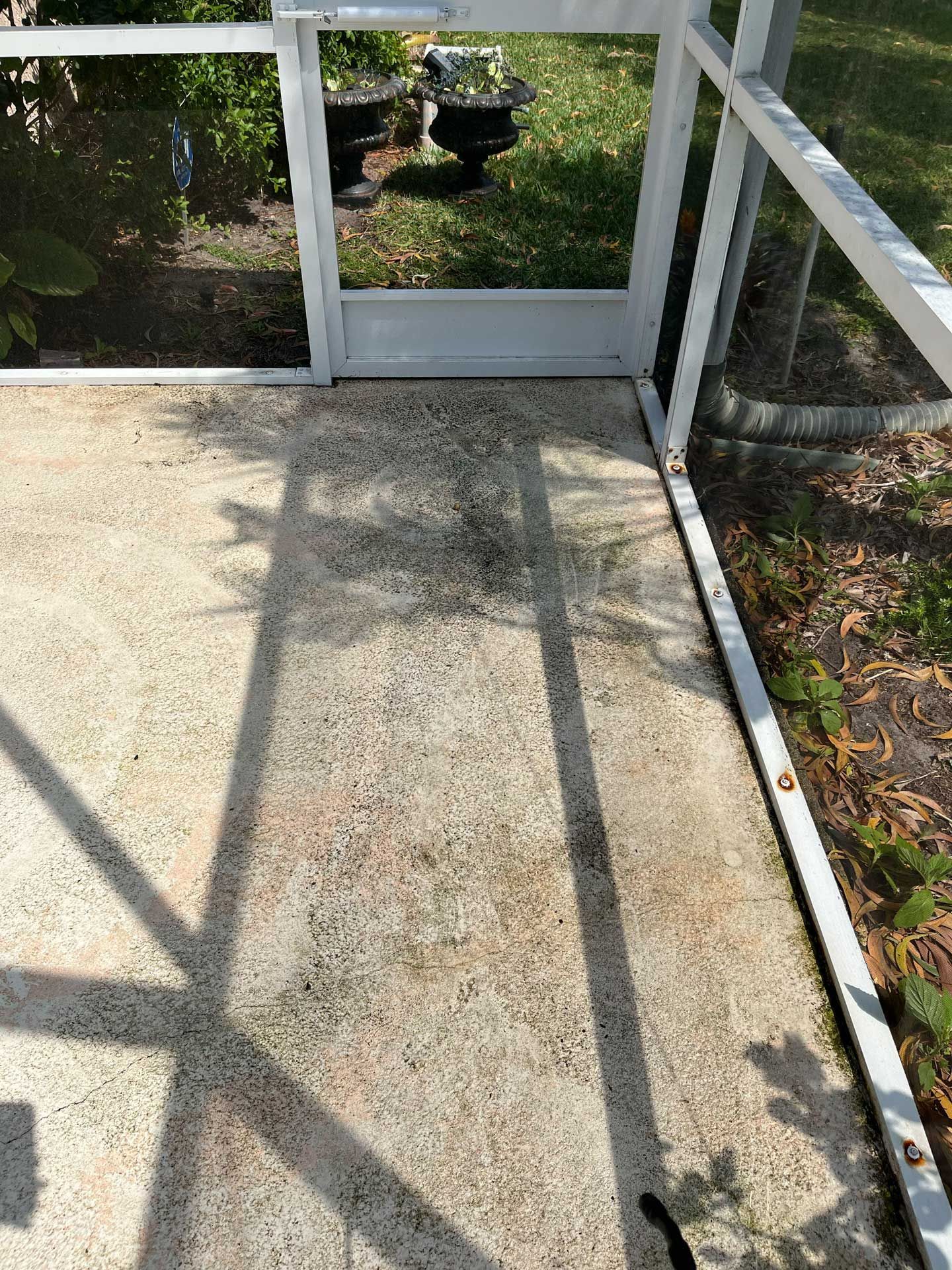 A dirty patio with a white railing and a shadow of a person on it.