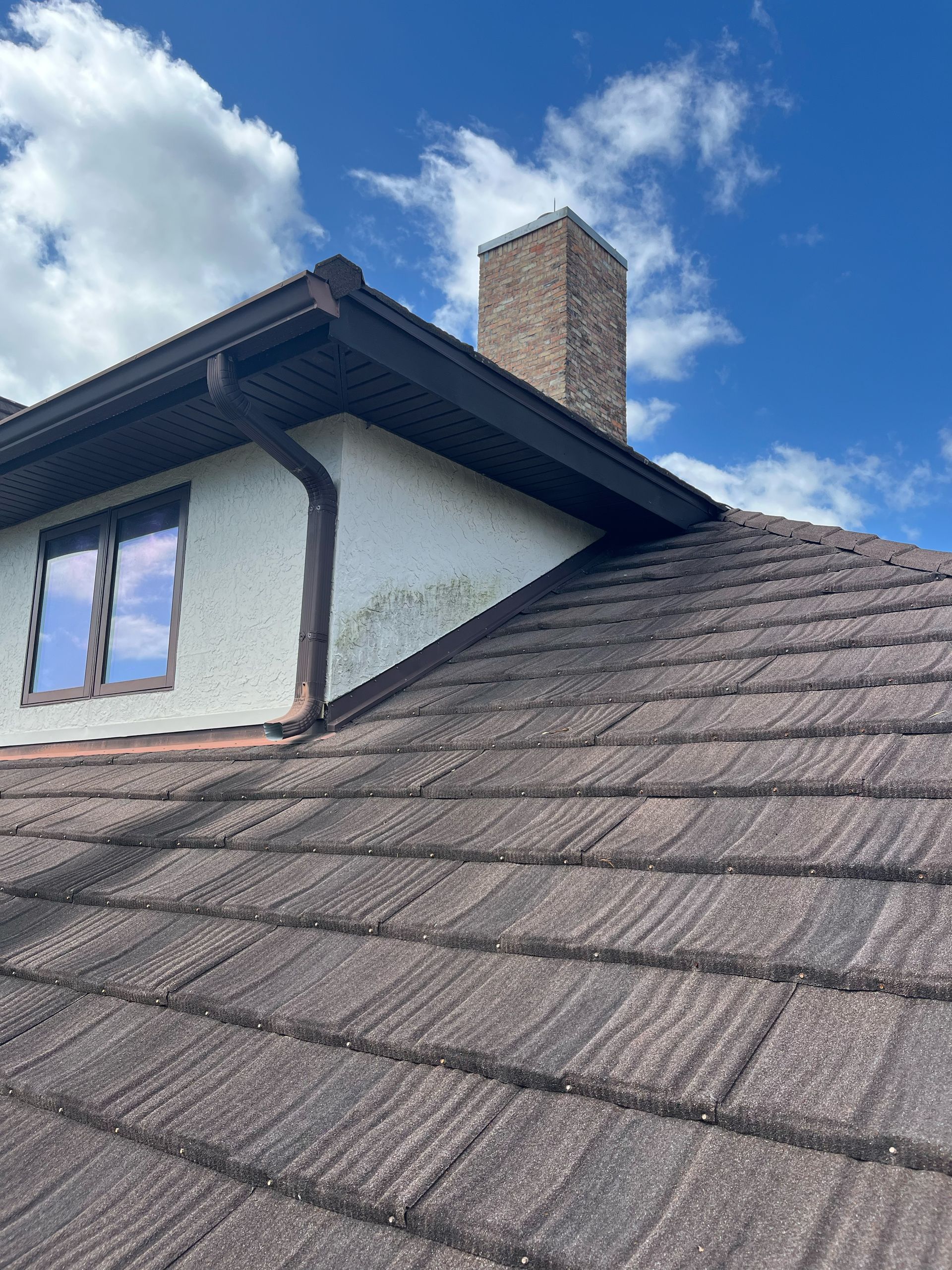 A roof of a house with a chimney on top of it.