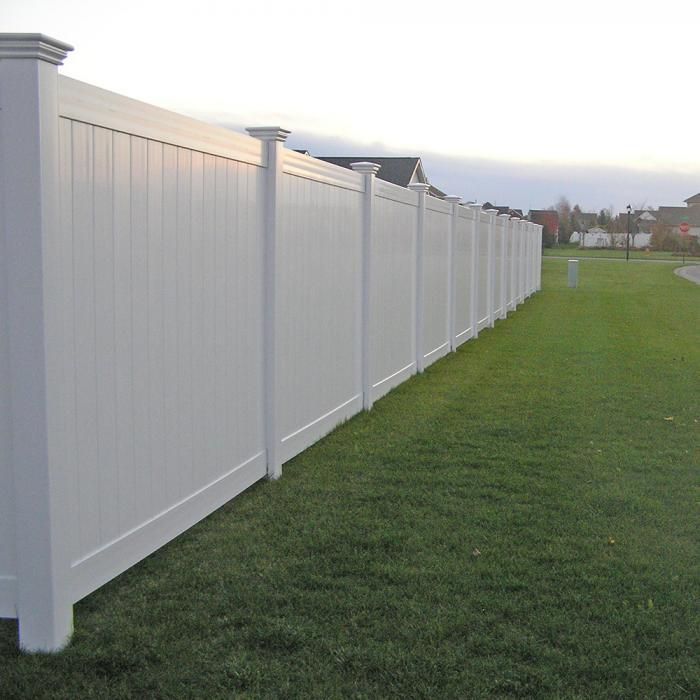 A concrete fence surrounds a lush green lawn.