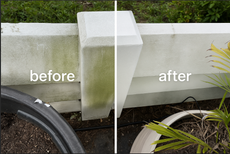 A brick driveway leading to a house with a roof.