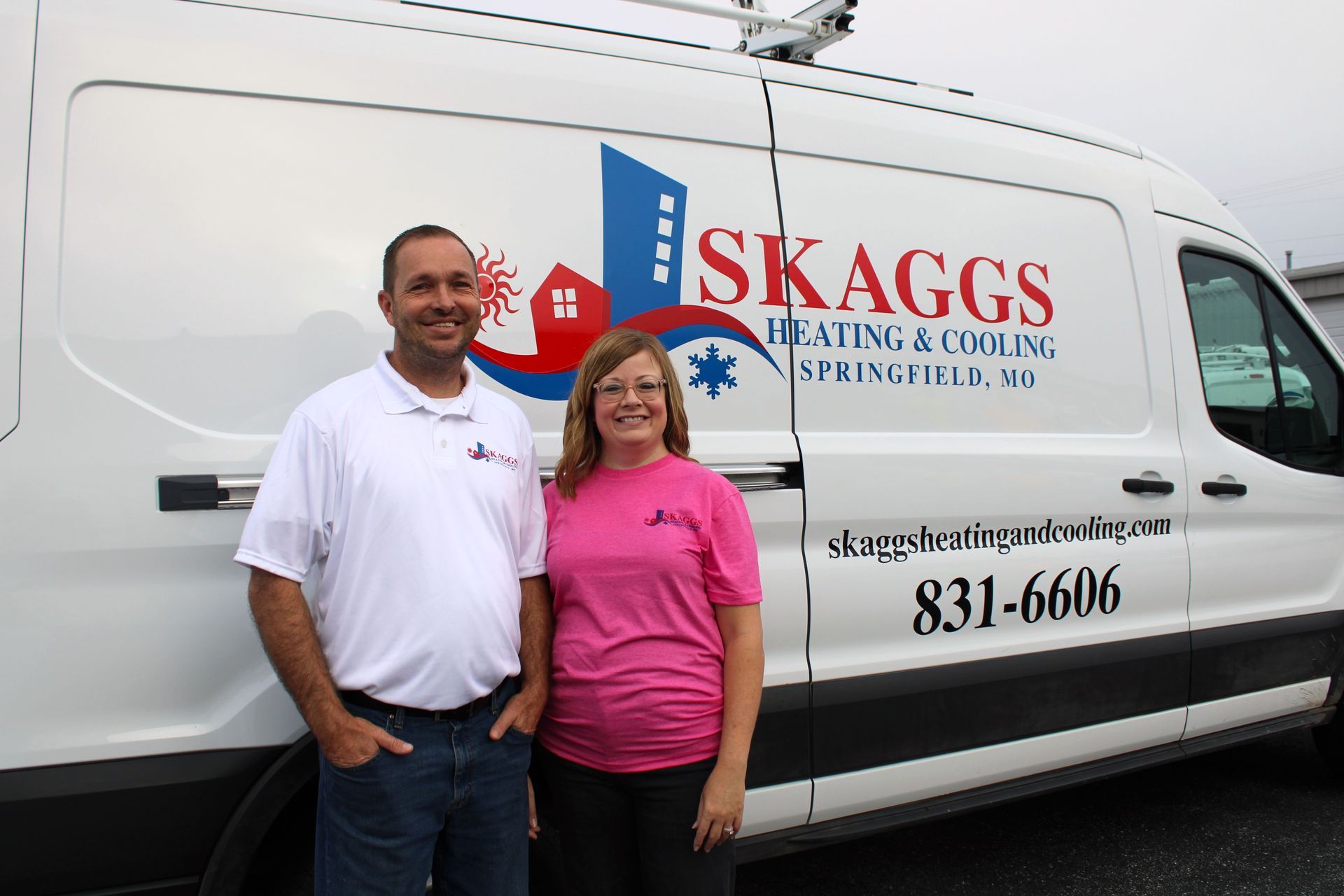 A man and woman standing in front of a skaggs van