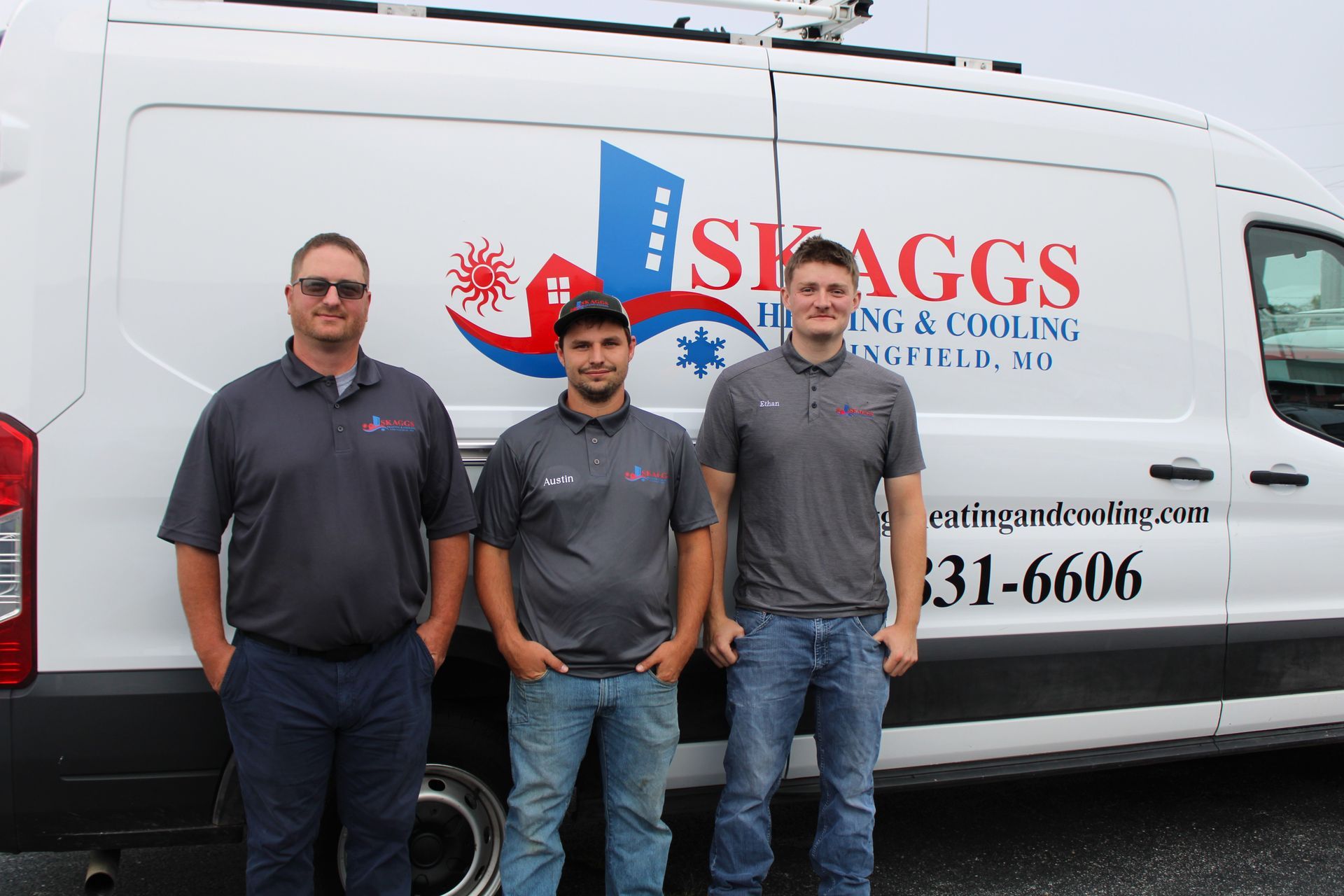 Three men are standing in front of a heating and cooling van.