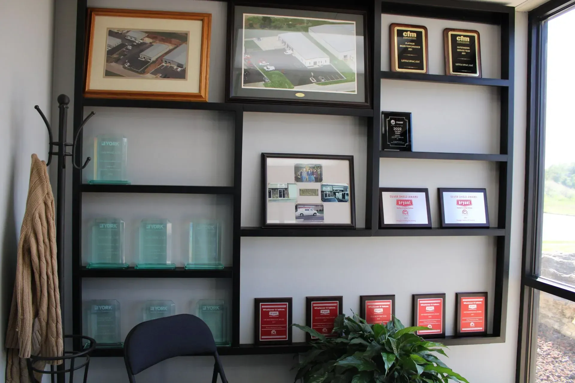 A room with a shelf full of trophies and pictures