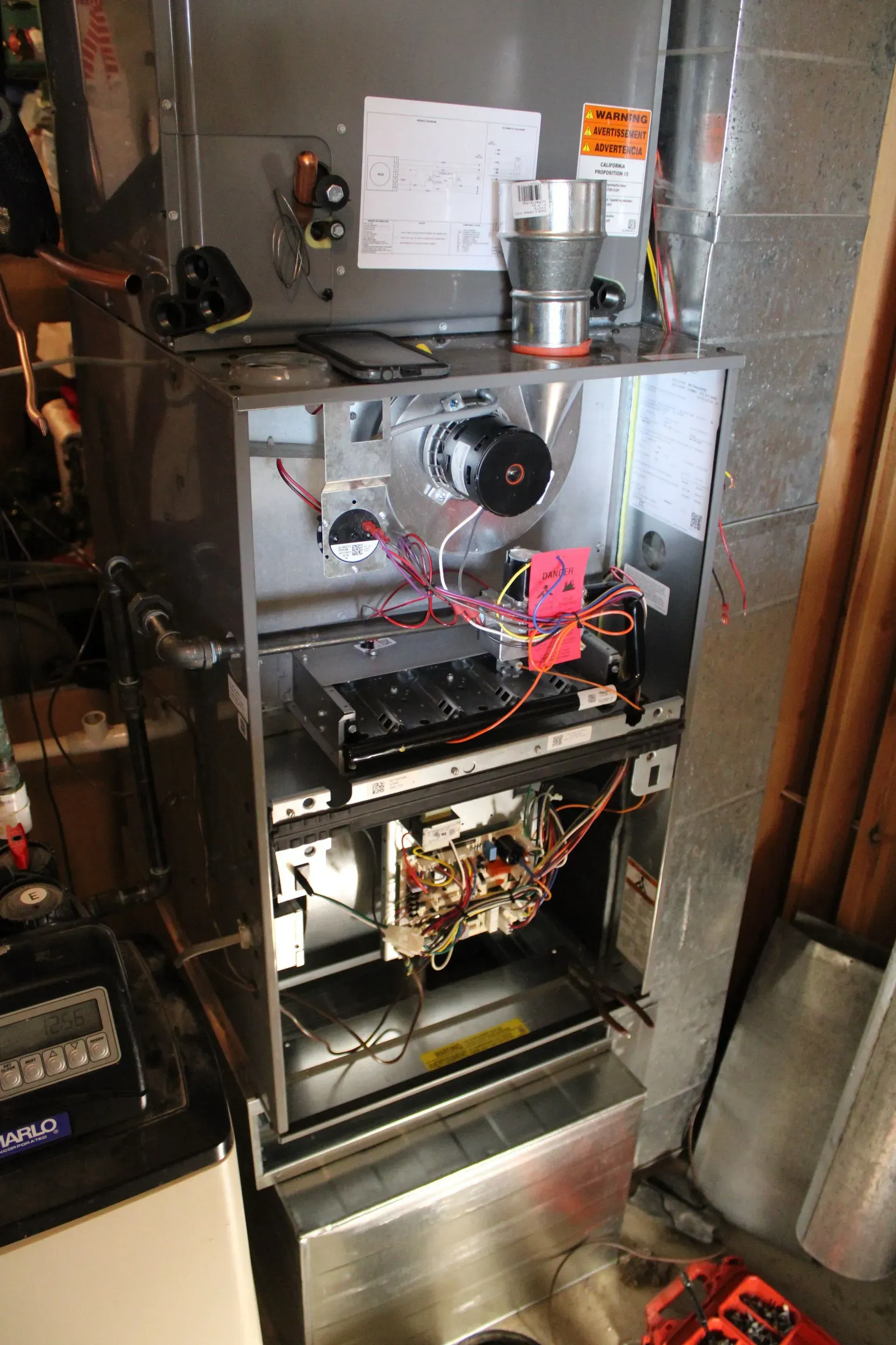 The inside of an air conditioner is being repaired in a garage.