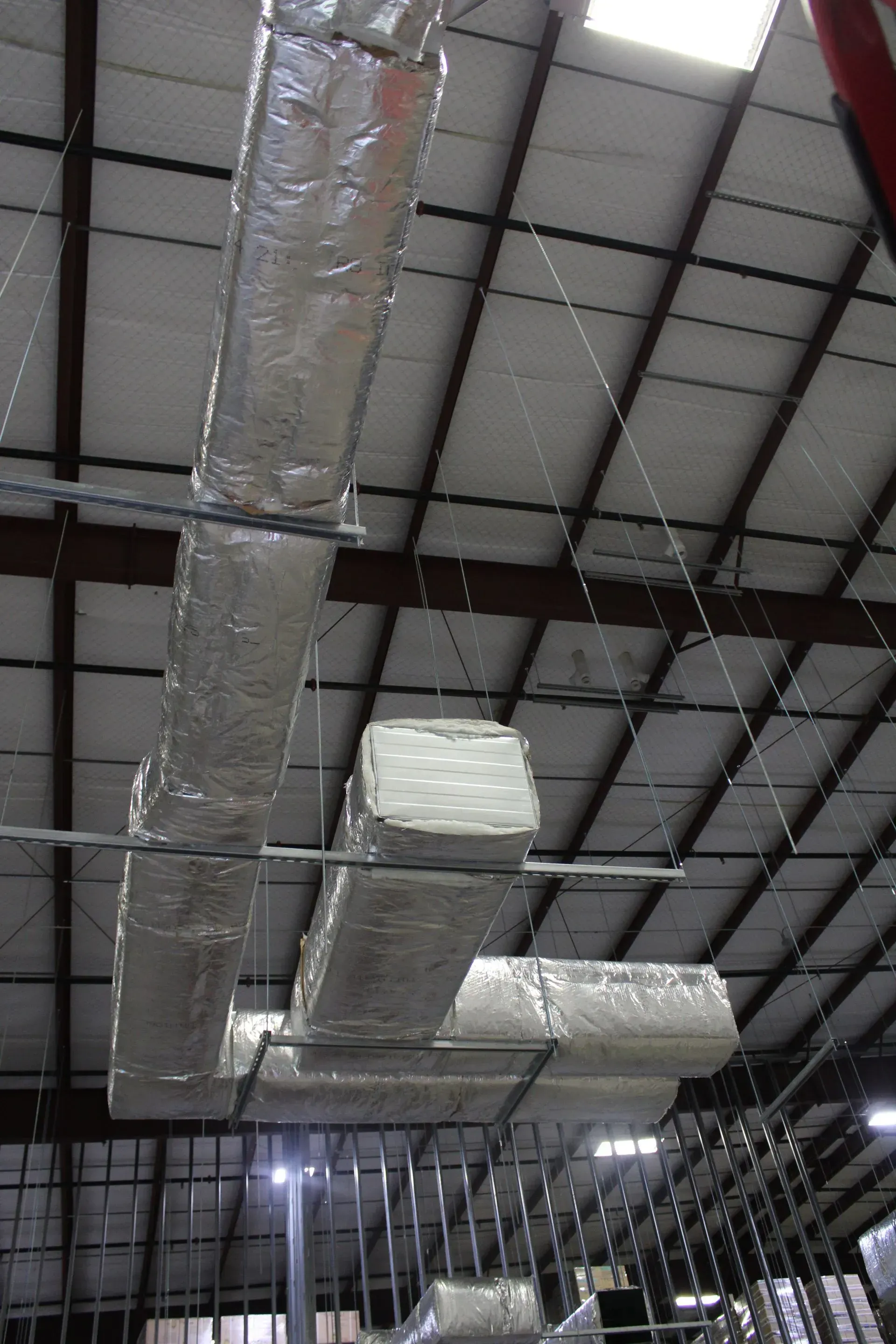 A ceiling with a lot of ducts hanging from it