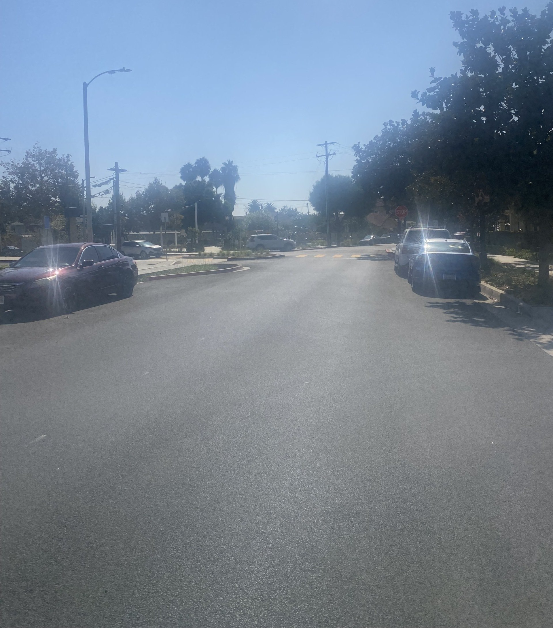 The first image is of a lot of cracked asphalt. The second image is of a bright orange hard hat sitting on an asphalt road.