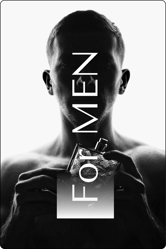 A black and white photo of a shirtless man holding a bottle of cologne.