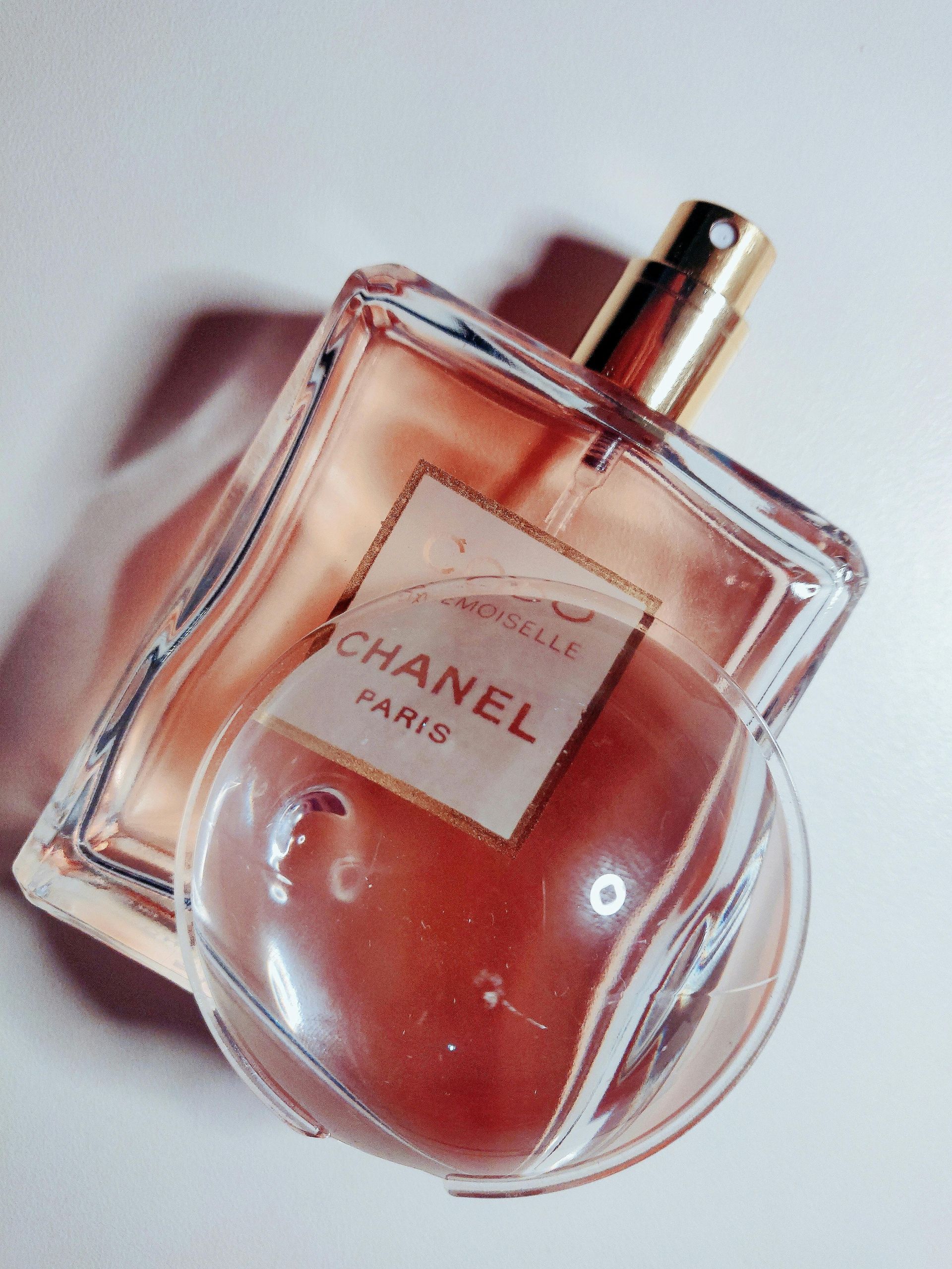 A bottle of chanel perfume sits on a white surface