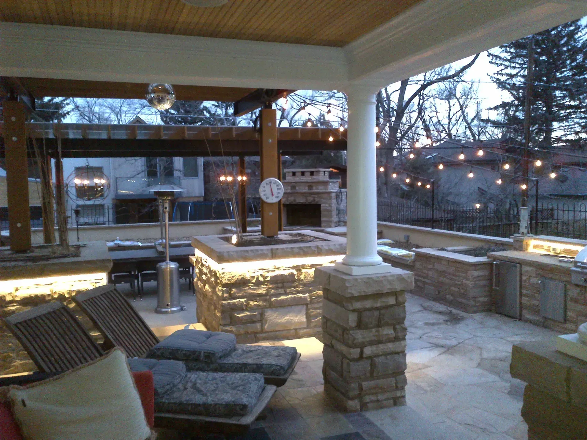 A patio with a fireplace and a clock on the wall