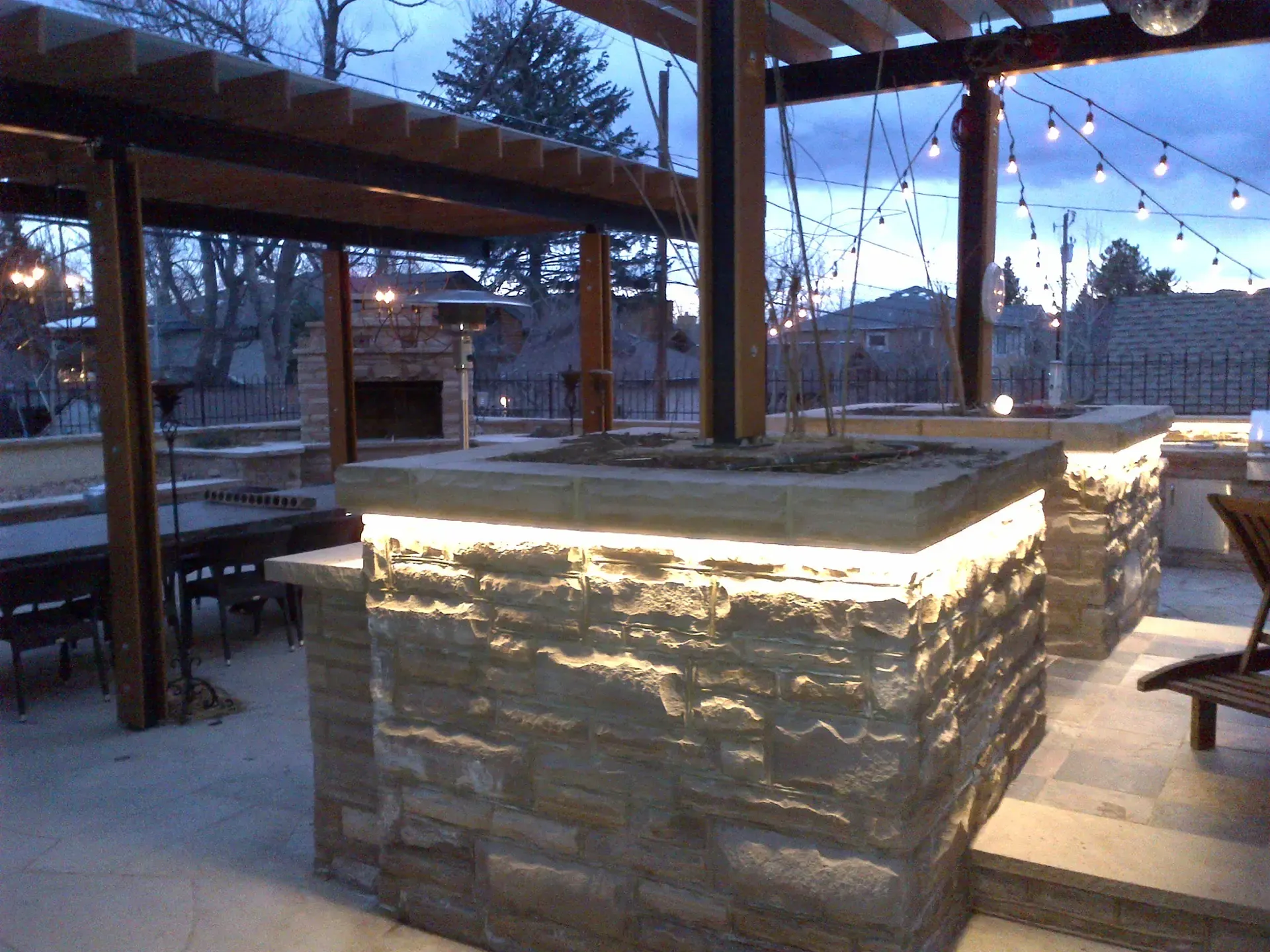A patio area with a brick bar and a fireplace