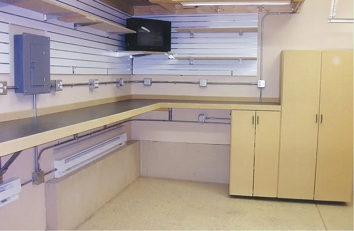 A room with shelves and cabinets and a tv on the wall