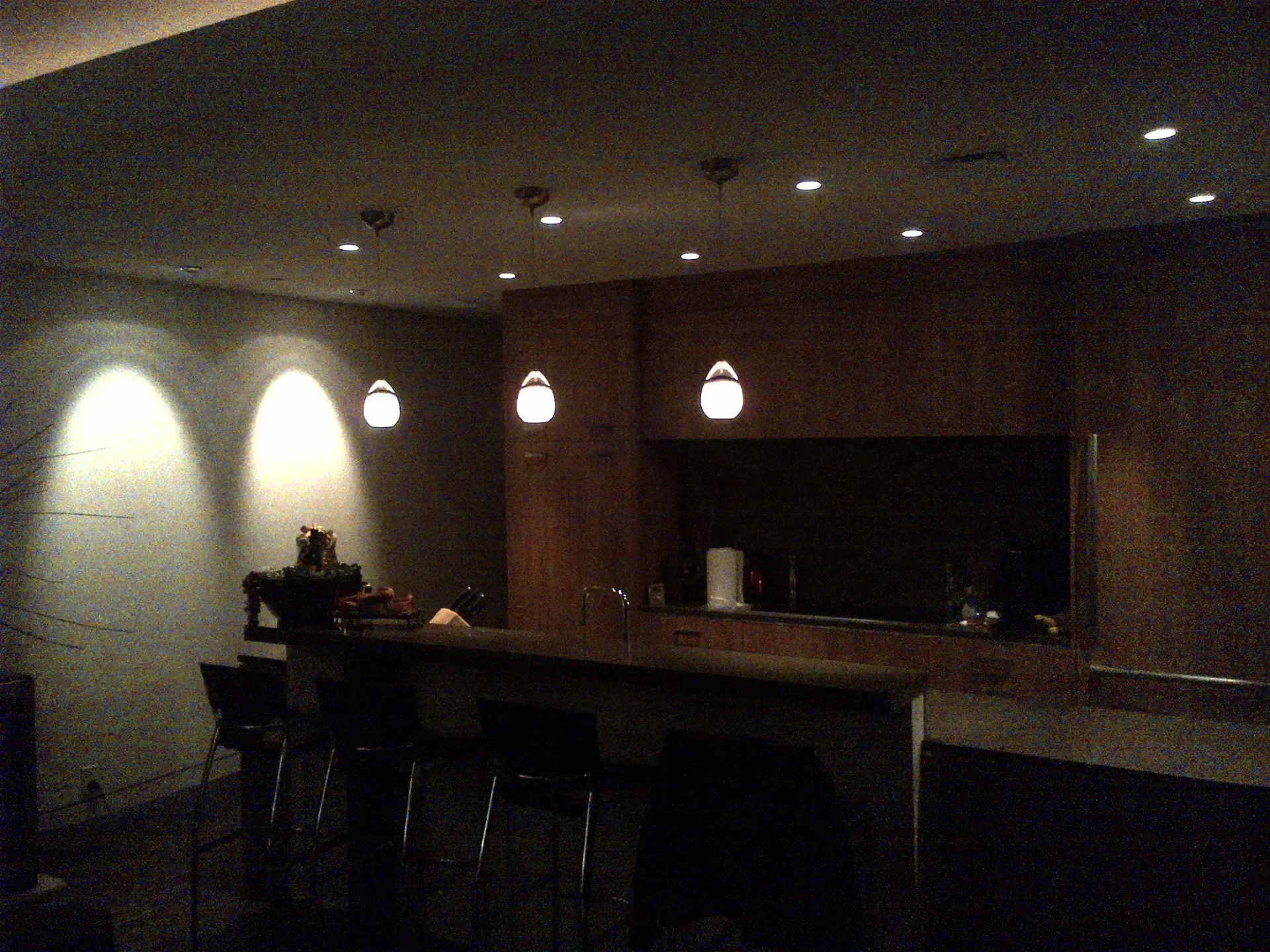 A dark room with a few lights hanging from the ceiling