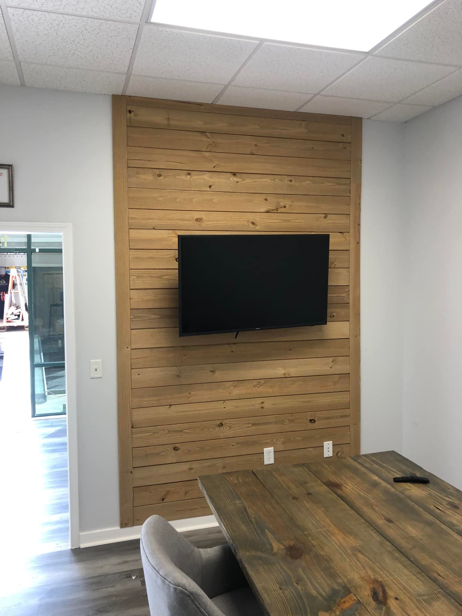A wooden wall with a flat screen tv mounted on it