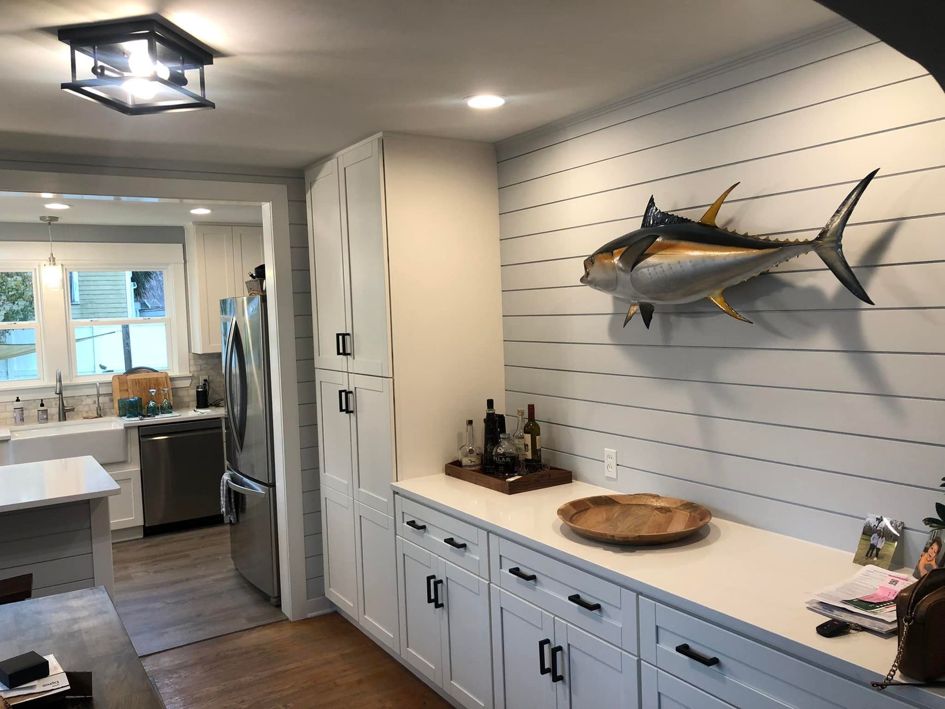 Kitchen with white cabinets, stainless steel fridge, and a large mounted tuna.