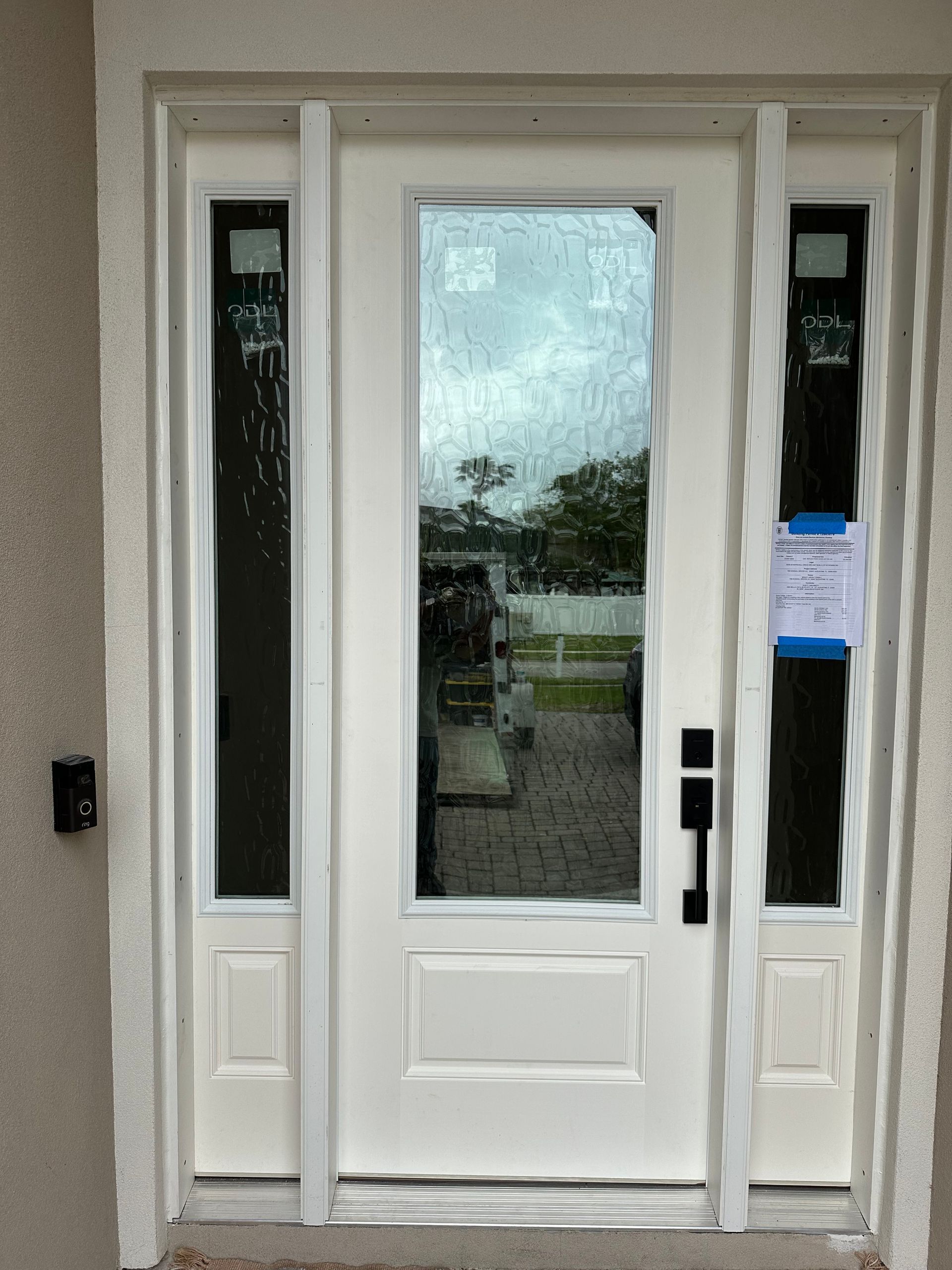 Barn door on a white paneled wall with a black track, installed against a gray wall.