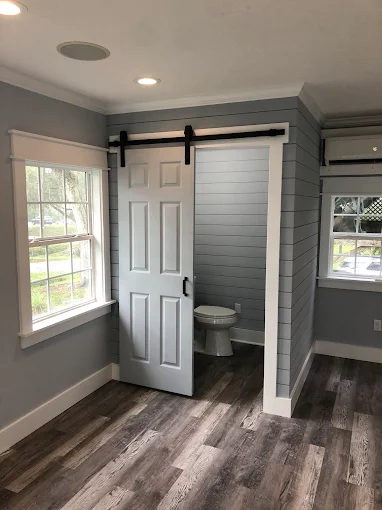 A room with a white wall and a desk in it.