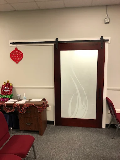 A room with a white wall and a desk in it.