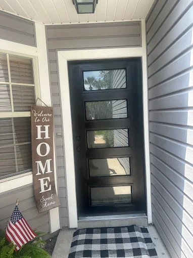 The front door of a house with a sign that says `` welcome to our home ''.