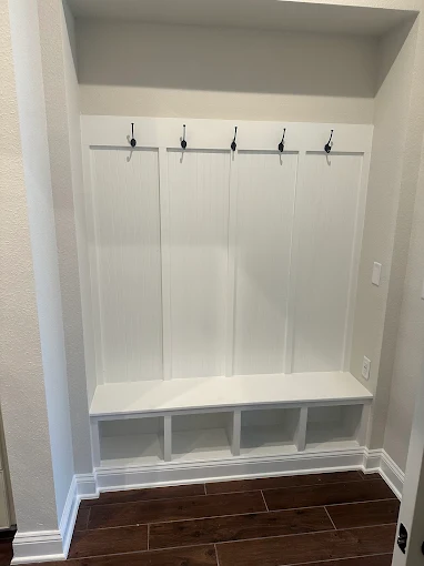 A room with a white wall and a desk in it.