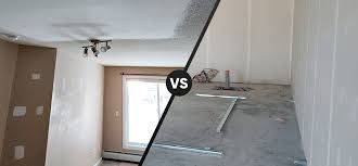 Renovation scene with a slanted floor panel, window, and exposed ceiling fan in a beige room