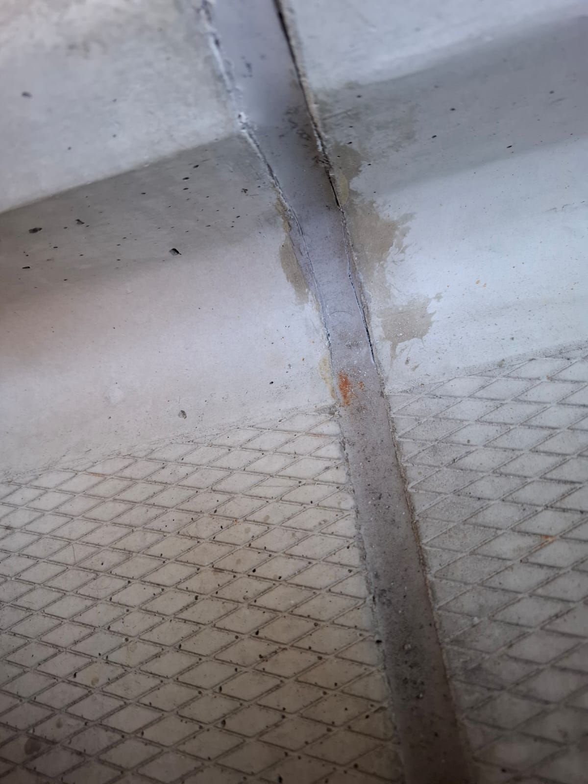 Lekkage onder betonnen trappen oplossen doormiddel van de oude kit verwijderen het beton schoon slijpen. Daarna primer erop en opnieuw kitten.