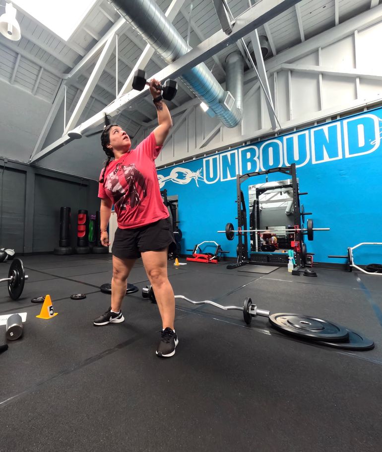 Athlete pressing a barbell overhead in the studio
