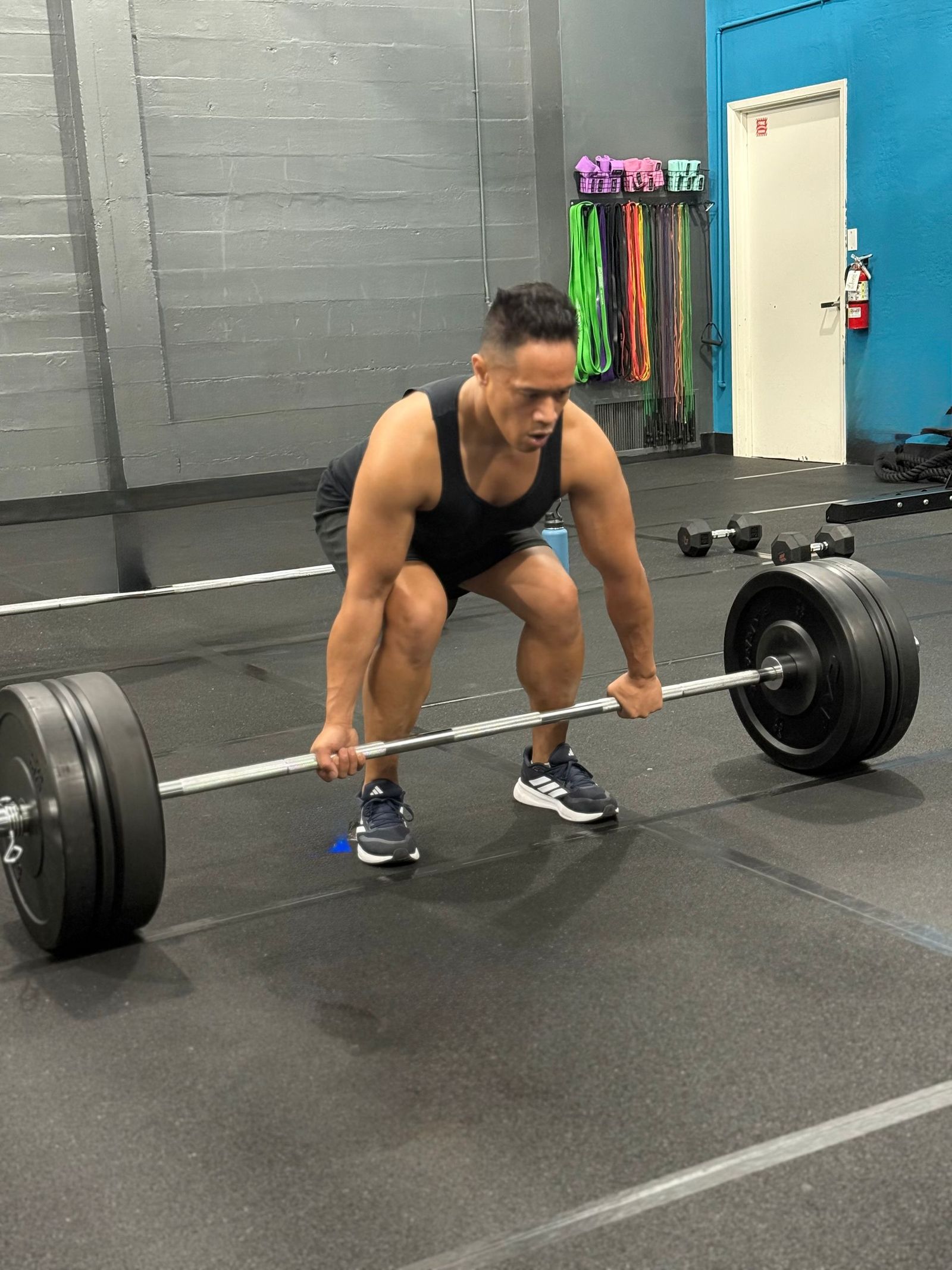 Coach performing a barbell deadlift inside the Unbound studio