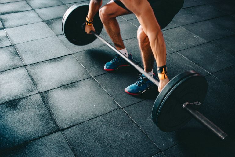 Athlete setting up a barbell deadlift on the studio floor