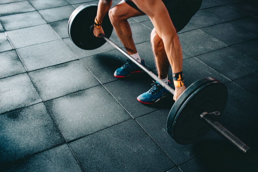 Athlete setting up a barbell deadlift on the studio floor