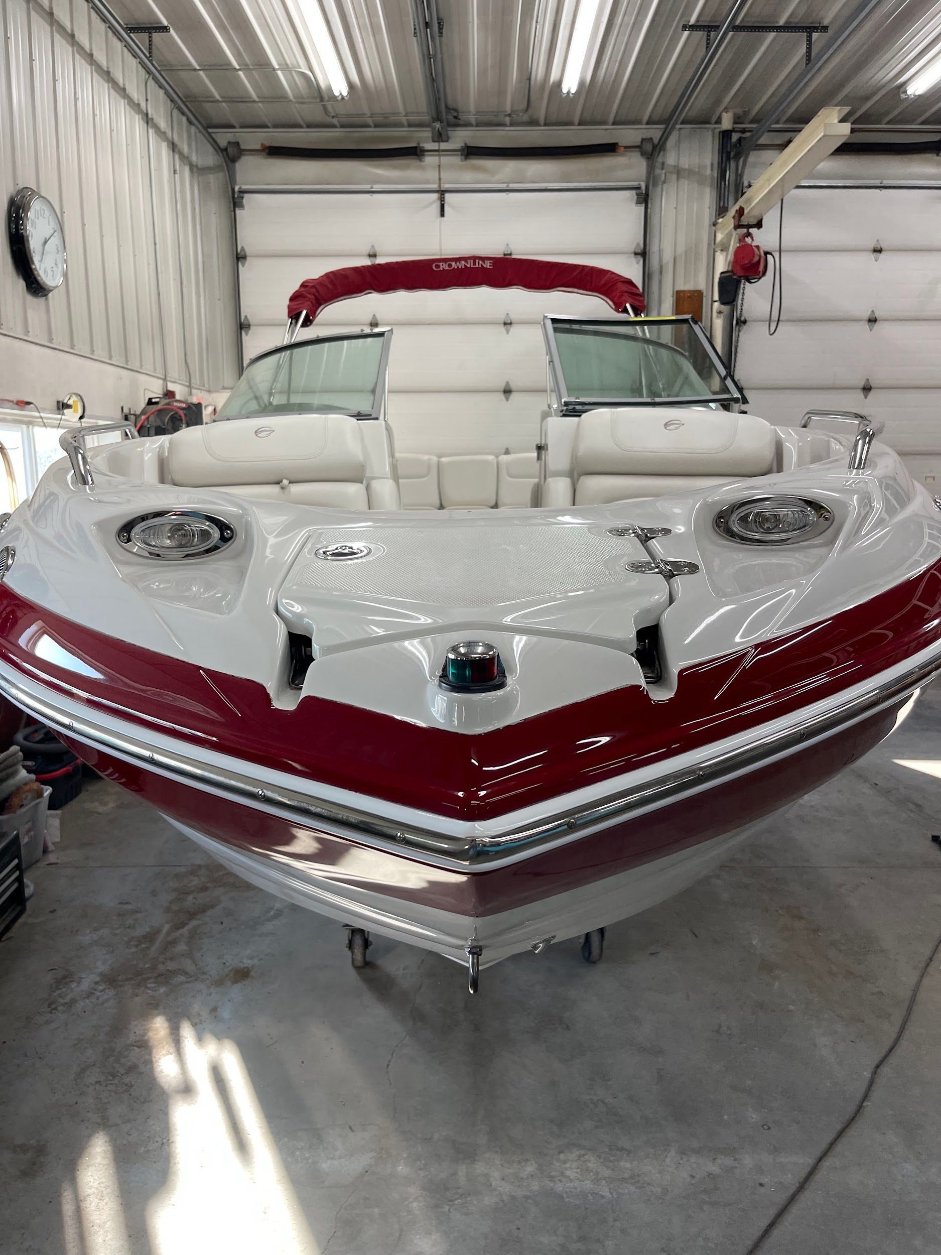 A red and white boat is sitting in a garage.