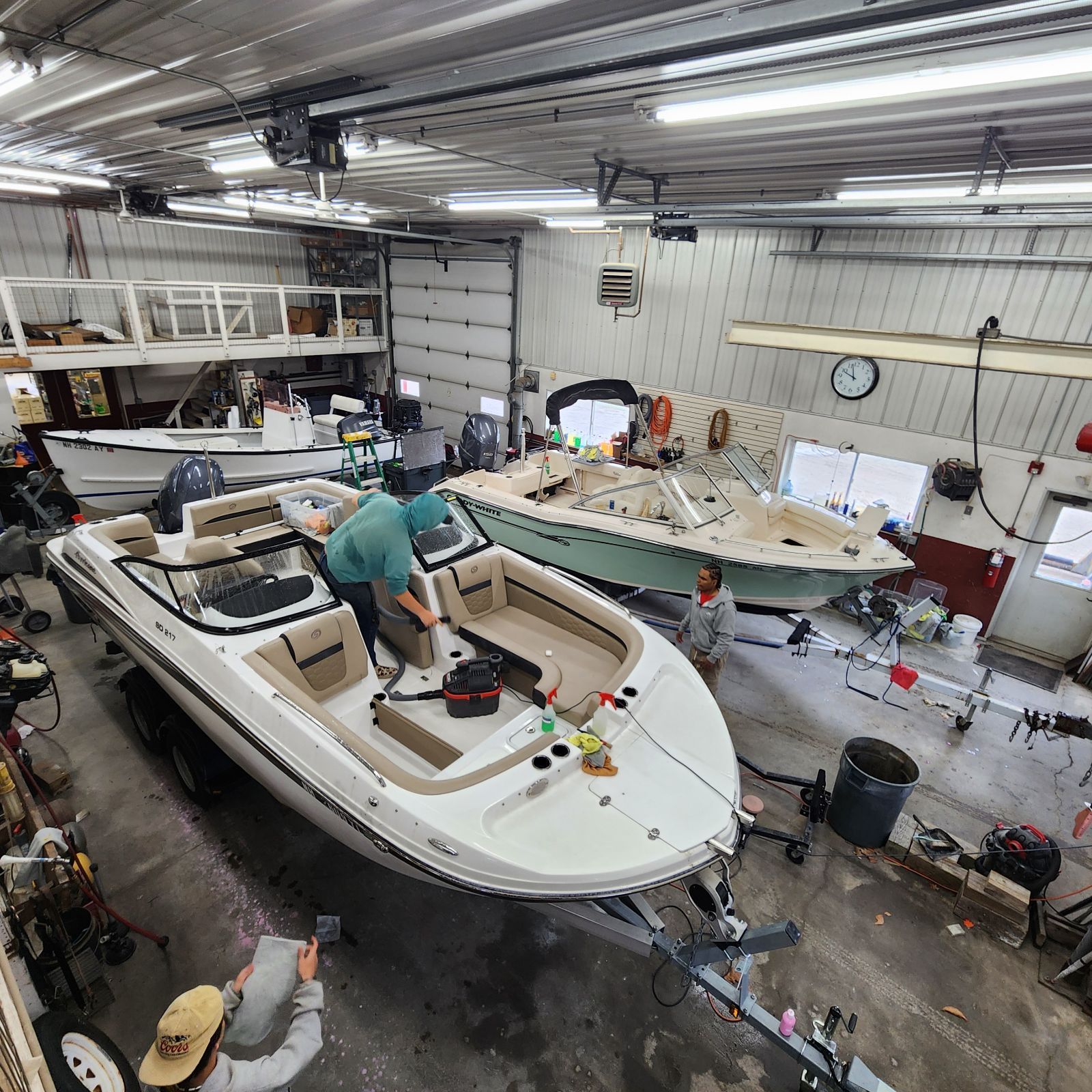 A man is working on a boat in a garage.