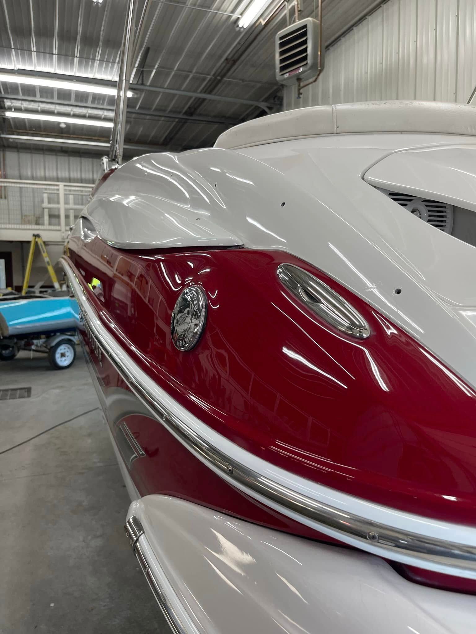 A red and white boat is parked in a garage.