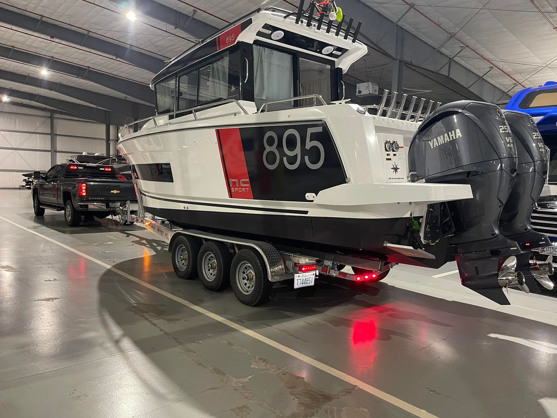 A boat is being towed by a truck in a warehouse.