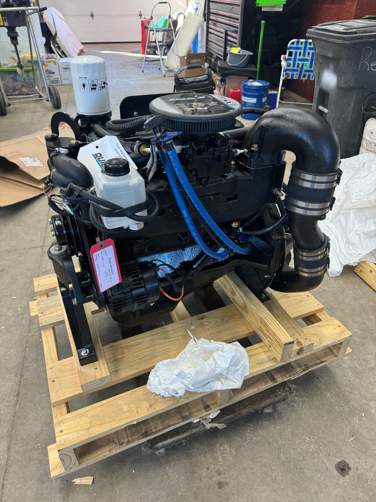 A black engine is sitting on top of a wooden pallet.