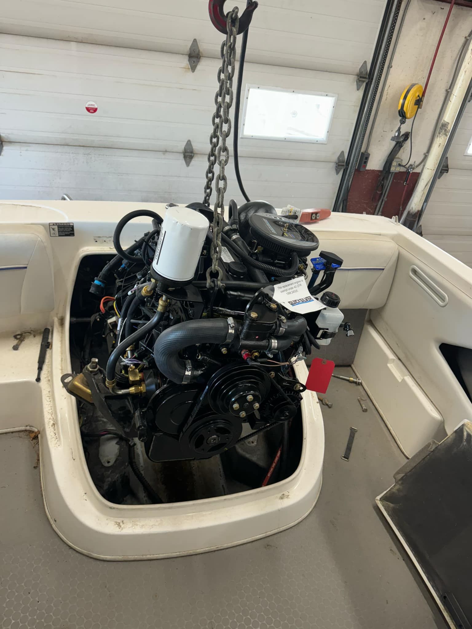 A boat engine is being lifted out of the water by a crane.