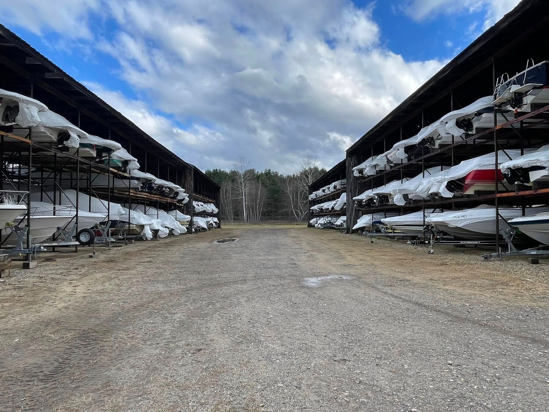A lot of boats are stacked on top of each other in a warehouse.