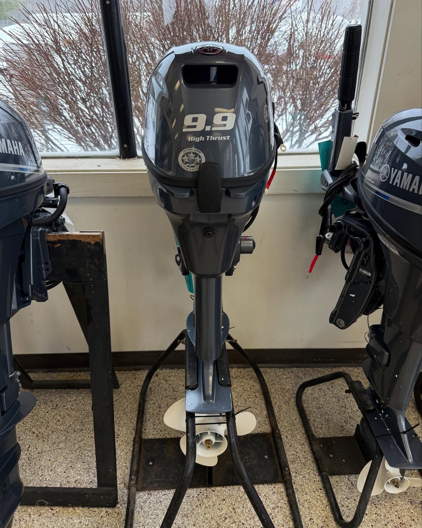 A yamaha outboard motor is sitting on a stand in a room.