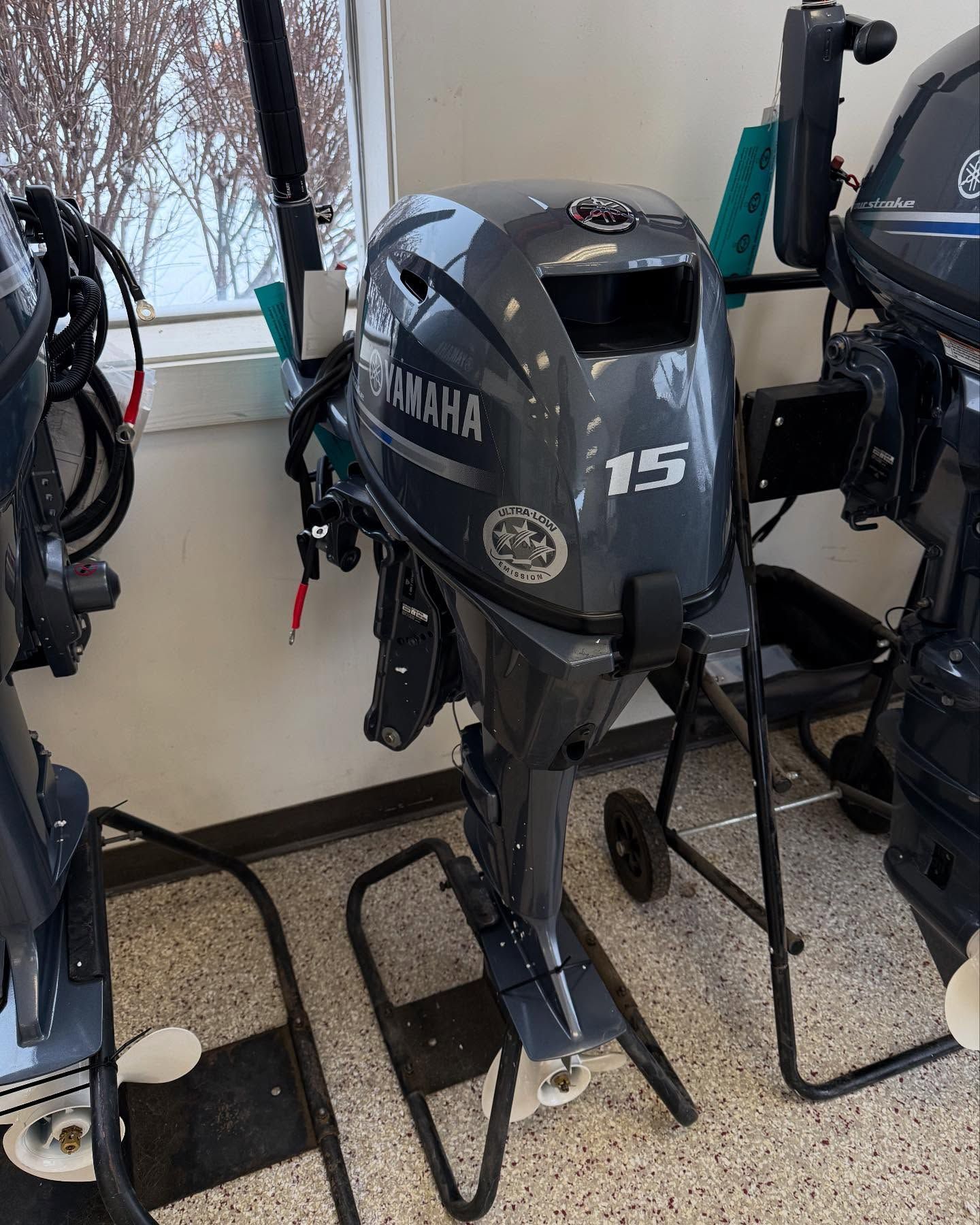 A yamaha outboard motor is sitting on a stand in a room.