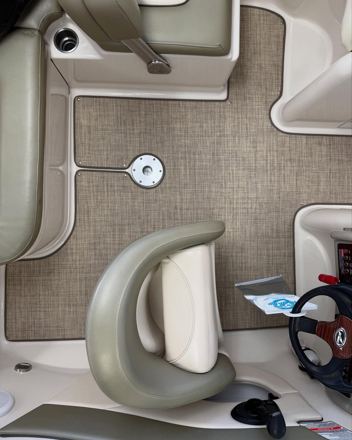 An aerial view of the interior of a boat with a steering wheel.