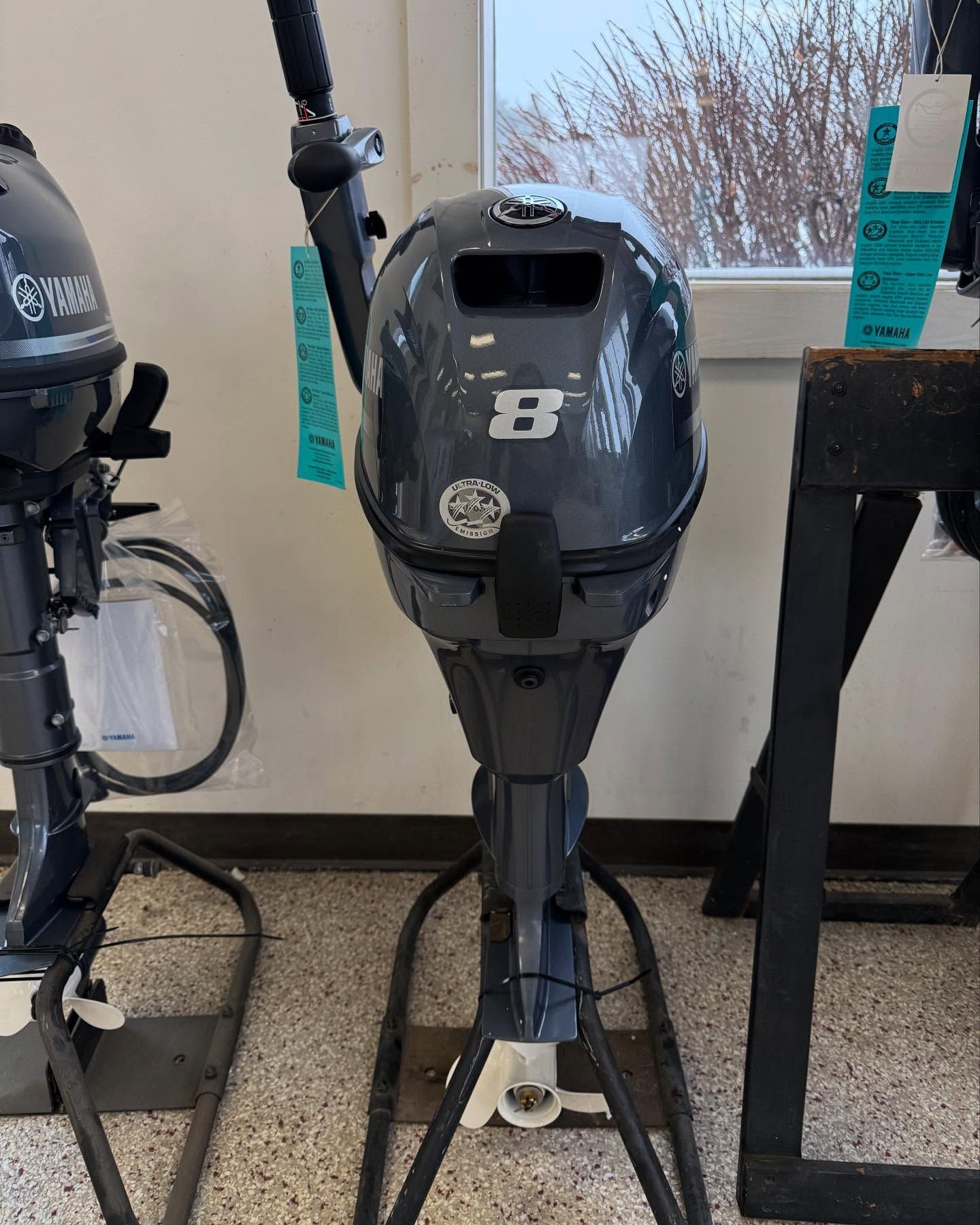 A yamaha outboard motor is sitting on a stand in a room.