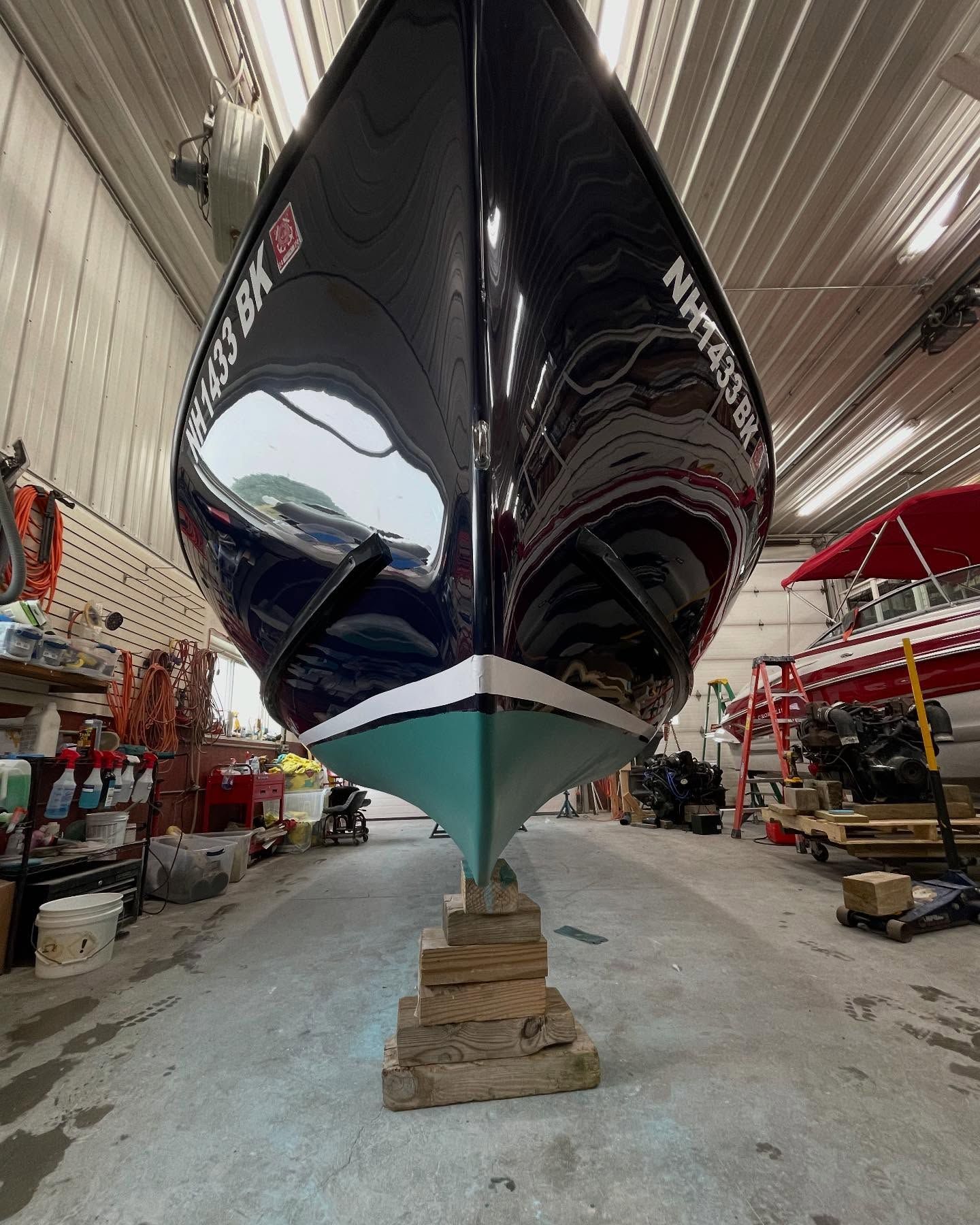 A boat is sitting on a wooden block in a warehouse.