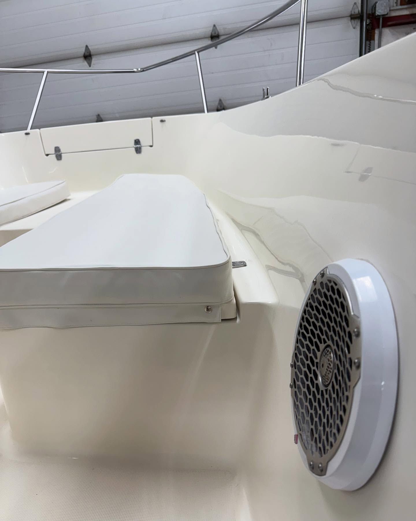 A white boat with a speaker on the side of it